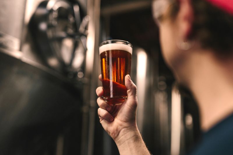 Man holding up a pint of beer from a Cotswold brewery