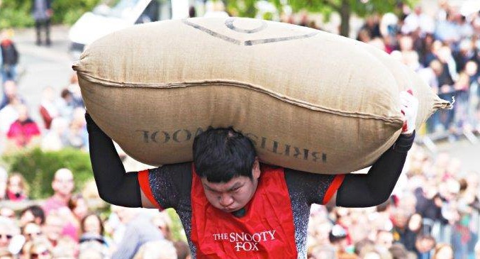 A competitor carrying the 70lb woolsack