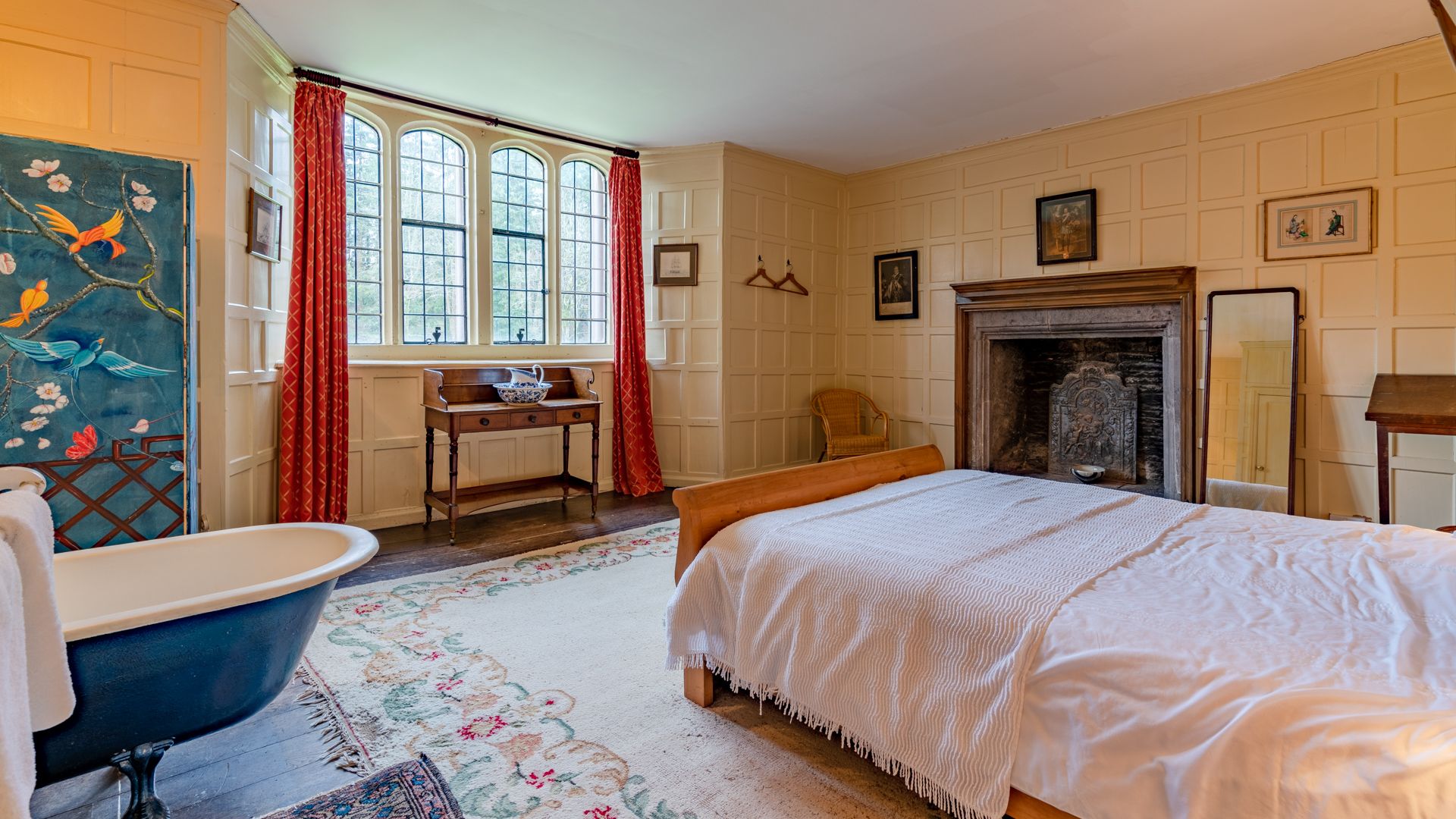 Kentchurch Court's elegant Painted Bedroom features a luxurious rolltop bath